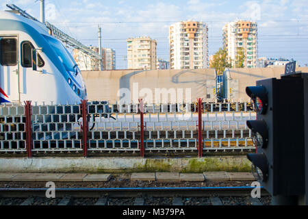 modern high speed train moves fast along the platform and red traffic light Stock Photo