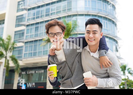 Best friends. Two guys hugging and walking in the city. Stock Photo