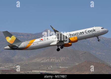 THOMAS COOK AIRBUS A321-200(S) G-TCDM ON TAKE-OFF FROM TENERIFE. MT.TEIDE VISIBLE IN THE BACKGROUND.  AIRCRAFT WEARS 'I LOVE MANCHESTER' TITLES. Stock Photo