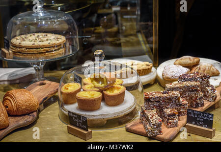 Various cakes and pastries on display in a shop. Stock Photo