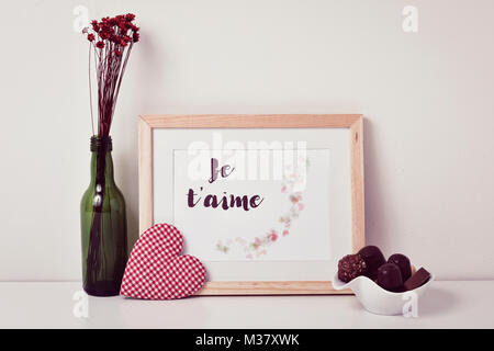 a picture with an illustration, made by myself, with some hearts and the text je t aime, I love you written in french, a heart, a bunch of dry flowers Stock Photo