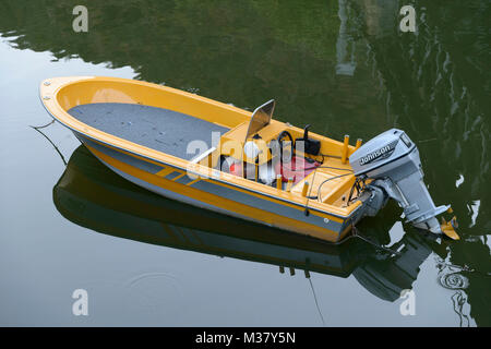 Small yellow speed boat with outboard motor Stock Photo