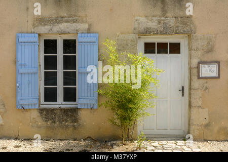 White door and window with blue wooden shutters in Labastide-d'Armagnac, Landes Department, Nouvelle-Aquitaine, Southwest France Stock Photo