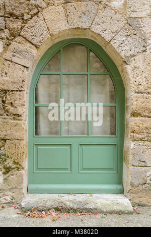 Green painted arched window on a building in Fourcès (Fources), Gers (Gascony), Occitanie (Midi-Pyrénées), Southwest France Stock Photo