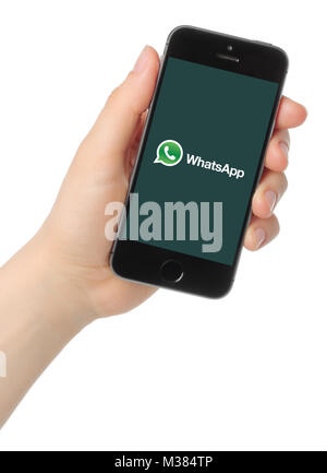 Kiev, Ukraine - March 7, 2015: Hand holds iPhone 5s Space Gray with WhatsApp logo on white background Stock Photo