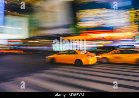 New York City - March 21, 2017 : Yellow taxi cab speeds down in a New York City Street. Shot with long shutter speed for intentional motion blur. Stock Photo