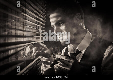 Gangster smoking a cigar while looking out the window at a car headlights Stock Photo