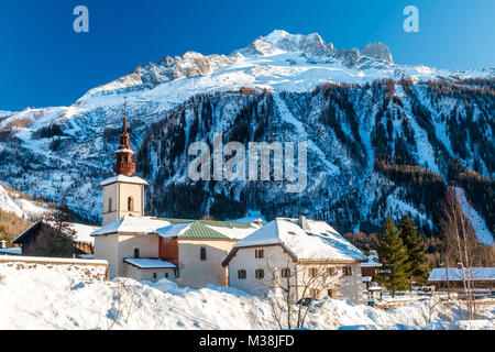 Argentiere Church in the centre of Argentiere church in winter.  The argentiere glacier in behind the village. Stock Photo