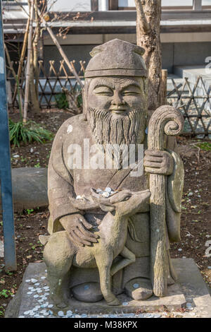 Kamakura, Japan - November 22, 2017 : Coins around statue of Jurojin (God of longevity) one of the Seven Gods of Fortune 'Shichifukujin', Myoryuji Bud Stock Photo