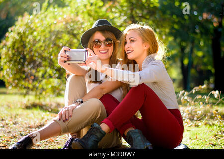 Urban girlfriends taking a selfie in the park Stock Photo
