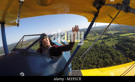 Al Tucker Jr., 96, waves from the front cockpit as he flies the PT-17 Stearman biplane owned by First Sgt. Dave Brown, U.S. Air Force Reserve, at the Flying Circus Aerodrome in Bealeton, Va., Jul. 30, 2017. Brown's PT-17 is the same model in which Tucker trained at West Point in 1942 before going on to fly P-38 fighter aircraft over Europe with the U.S. Army Air Corps 434th Fighter Squadron during WWII with his friend, then Lt., Robin Olds. The two have been flying together for nearly 10 years. (U.S. Air Force photo by Pete Ising) Always Welcome [Main Track] by AirmanMagazine Stock Photo