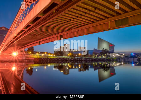 Lowry Footbridge and Imperial War Museum North at night, Salford Quays, Greater Manchester, England, UK Stock Photo