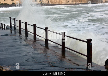a rough sea during a coastal storm battering the guardrail or railings on the seafront. Coastal gales and rough seas in the UK at the seaside or coast Stock Photo