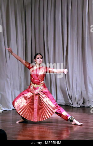 Kuchipudi dancer balancing herself on the rim of a brass plate in