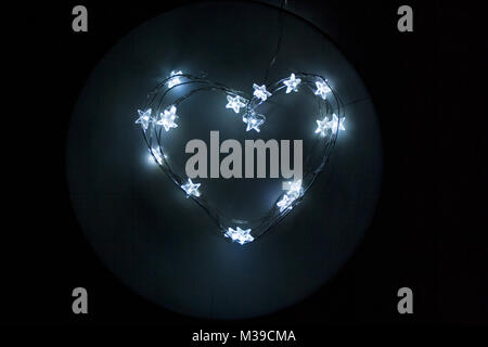 Garland with star shaped lights as a heart shaped silhouette Stock Photo