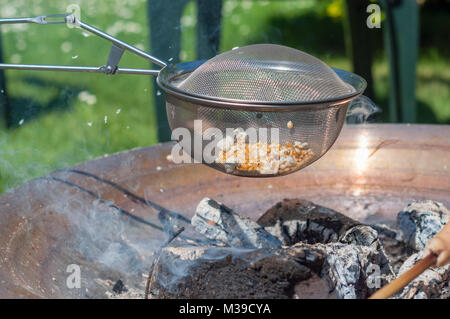 Popcorn over open fire on a warm day Stock Photo