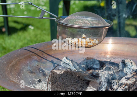 Popcorn over open fire on a warm day Stock Photo
