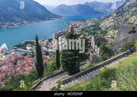 Tourist path on the ancient walls to Saint John Fortress above Kotor town with aerial view on Bay of Kotor, Montenegro Stock Photo