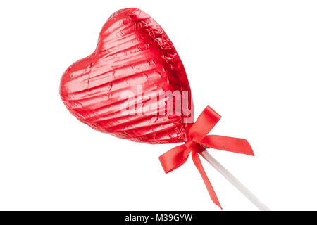 Red Chocolate love heart lollypop with a red ribbon bow on a stick. Isolated on a white background angled Stock Photo