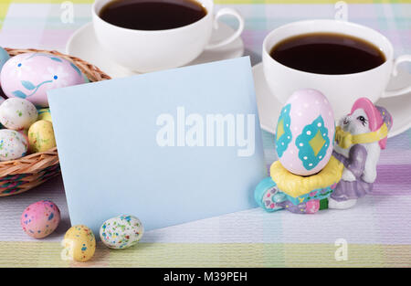 Closeup of a blank envelope with Easter candy and decorated egg and coffee in background Stock Photo