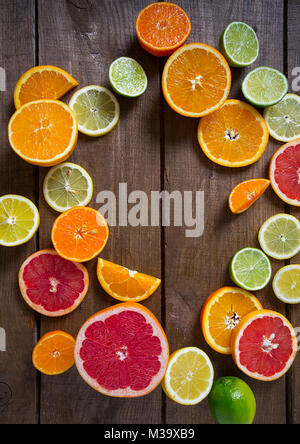 mixed citrus fruits on dark wooden background Stock Photo