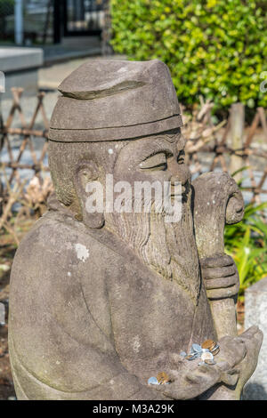 Kamakura, Japan - November 22, 2017 : Coins around statue of Jurojin (God of longevity) one of the Seven Gods of Fortune 'Shichifukujin', Myoryuji Bud Stock Photo