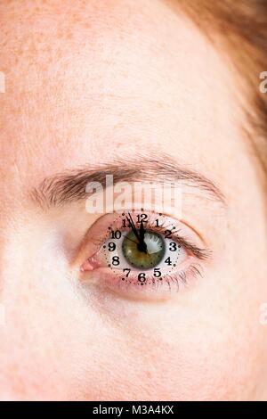 MODEL RELEASED. Composite close-up image of a female eye with clock. Stock Photo