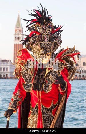 Venice, Veneto, Italy, 10th February 2018. Colourful costumes at the Venice Carnival on a sunny day on the last weekend of the festival. People posing on San Giorgio Maggiore Island at sunset. Stock Photo