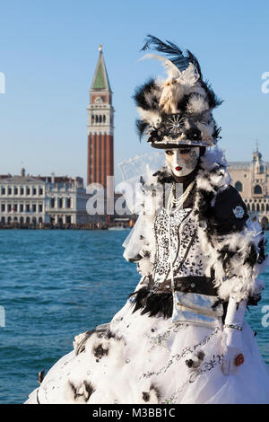 Venice, Veneto, Italy, 10th February 2018. Colourful costumes at the Venice Carnival on a sunny day on the last weekend of the festival. People posing on San Giorgio Maggiore Island at sunset. Stock Photo