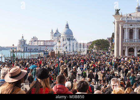 Venice, Veneto, Italy, 10th February 2018. Crowds on Riva degli Schiavoni and Piazzetta San Marco on the last weekend of the carnival with Basilica di Santi Maria della Salute in the background. Eighty thousand people are thought to have attended the carnival on Saturday.. Credit MCpics/Alamy Live News Stock Photo