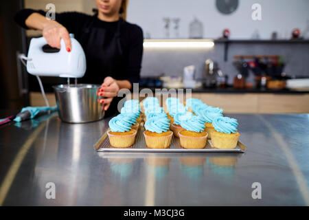 The confectioner with a pipping bag of cream in his hands decore Stock Photo