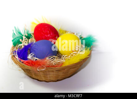 colored easter eggs and nests with colored feathers Stock Photo