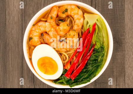 Japanese Style Prawn And Noodle Ramen Soup With Pak Choi And Chillies On A Dark Wooden Table Stock Photo