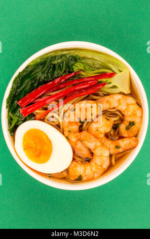 Japanese Style Prawn And Noodle Ramen Soup With Pak Choi And Chillies Against A Green Background Stock Photo