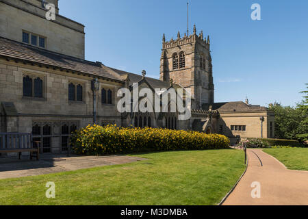 Under a deep blue sky, an exterior view of Bradford Cathedral with its squat, square tower & peaceful gardens - Bradford, West Yorkshire, England, UK. Stock Photo