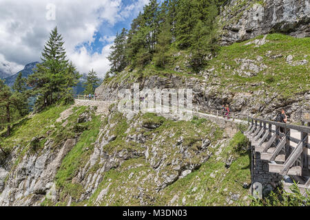 People at hiking trail through Austrian mountains to ice cave Stock Photo