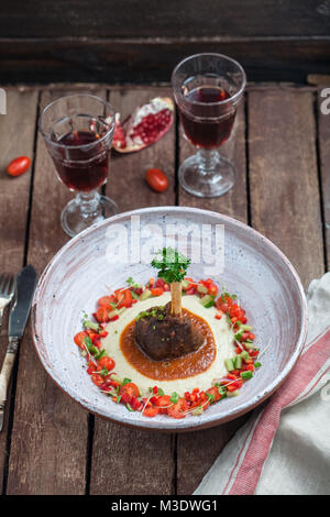 Lamb shank with eggplant puree and fresh vegs, traditional turkish dish Stock Photo