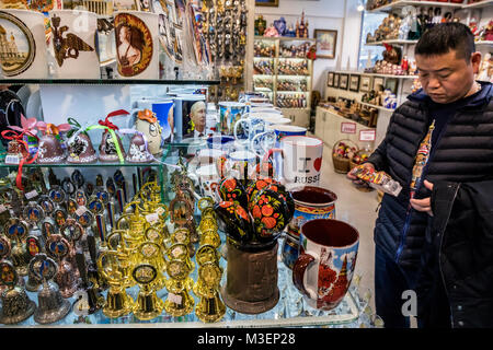 Chinese tourist selects souvenirs in a souvenir shop on Nikolskaya street in the center of Moscow, Russia Stock Photo