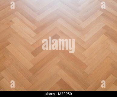 wooden floor - herringbone parquet closeup - oak parquet Stock Photo