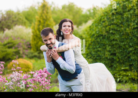 Smiling happy married couple posing in hugs at the blossom park Stock Photo