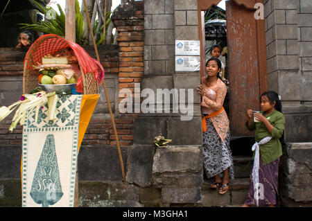 Teenagers at the door of a temple during the celebration of Galungan. Ubud city, Indonesia Stock Photo