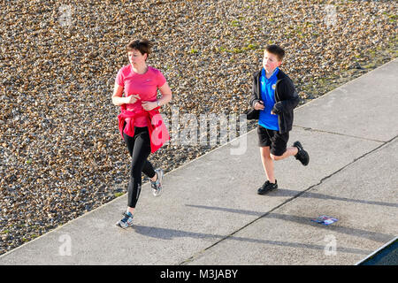 Lyme Regis, Dorset, UK.  11th February 2018.  UK Weather.  Joggers on the seafront enjoying the clear skies on a sunny morning at Lyme Regis in Dorset during the school half term holidays.  Picture Credit: Graham Hunt/Alamy Live News. Stock Photo