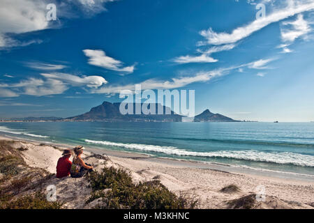 South Africa, Cape Town, Blouberg beach. Couple relaxing. Background Table mountain. Stock Photo