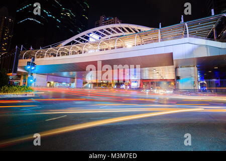 public sky walk and traffic at Chong Nonsi sky train station at night, Bangkok, Thailand Stock Photo