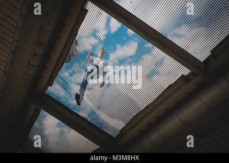 London (UK) - August 2017. Man walking on gratings on the Millennium Bridge. Landscape format. Stock Photo