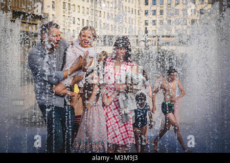 London (UK) - August 2017. Family with children and kids playing in a fountain near the Royal Festival Hall in South Bank. Landscape format. Stock Photo