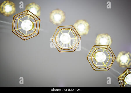 Gold colored wire frame hanging lamps. Bottom view. Landscape format. Stock Photo