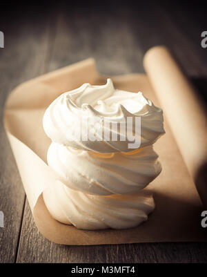 Stack of three meringue nests on parchment paper fresh out of the oven Stock Photo