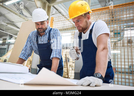 Two Construction Workers Inspecting Plans Stock Photo