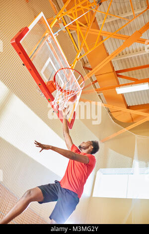 Basketball player making slam dunk Stock Photo